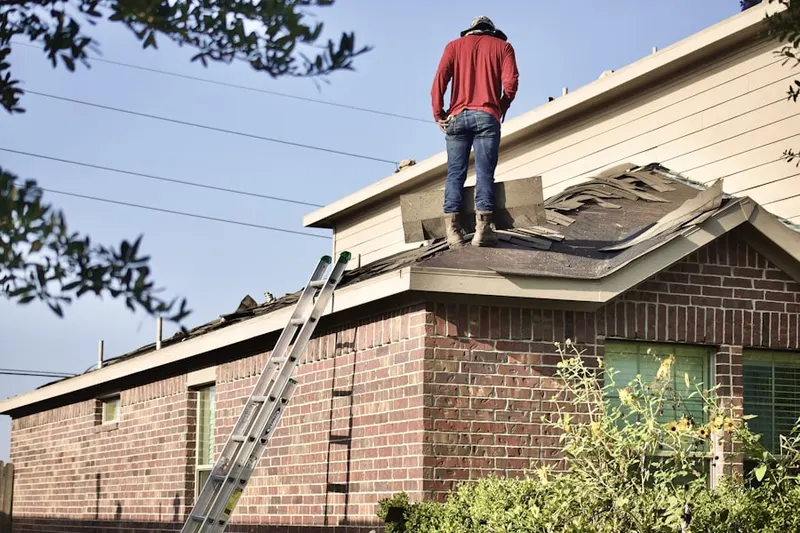 Professional roofer working on a residential roof in Elma